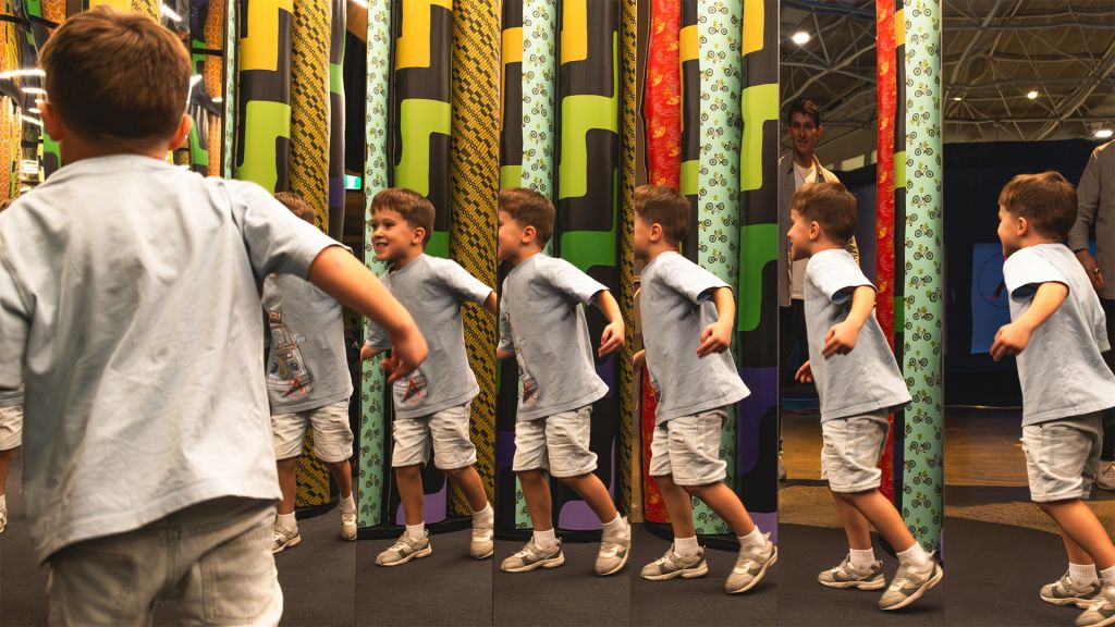 Multiple reflections of a child walking through the mirror maze